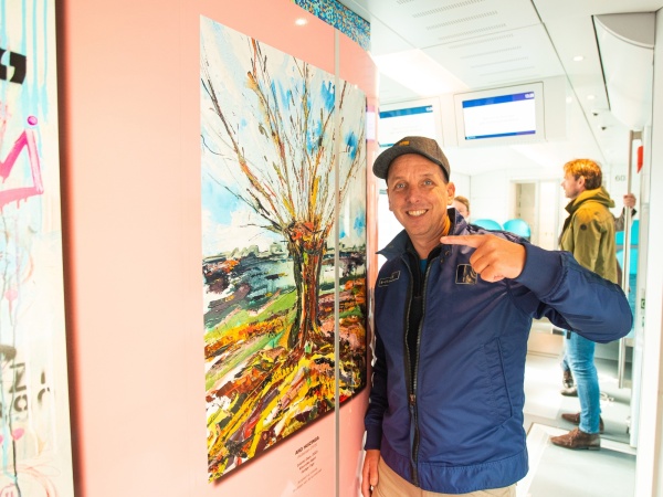Ard Huizinga bij zijn kunstwerk in de Arriva-trein, foto: Arriva